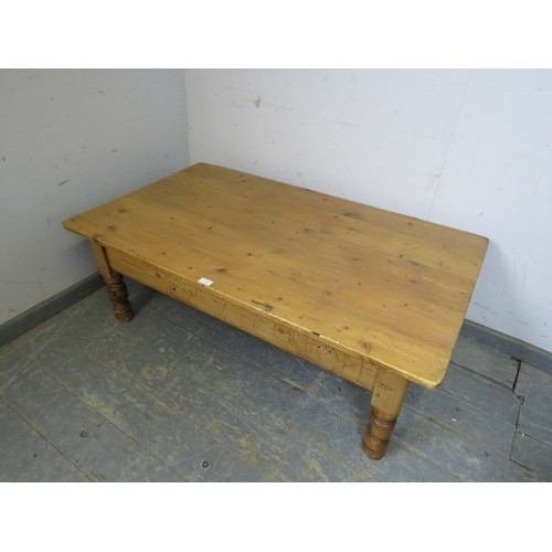 740 - A rectangular antique pine coffee table, the planked top raised on turned supports. 
H43cm W127cm D7... 