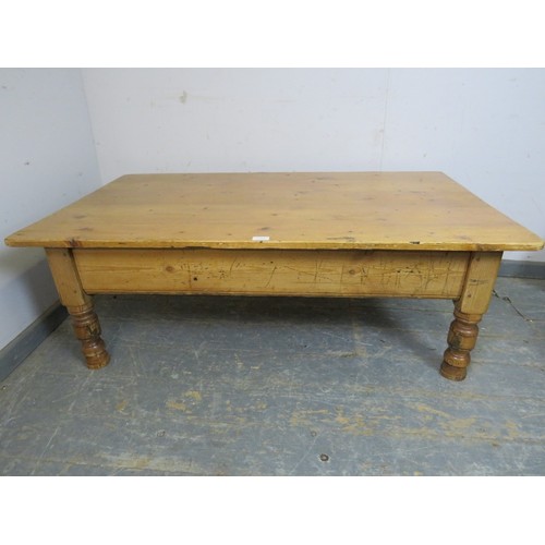 740 - A rectangular antique pine coffee table, the planked top raised on turned supports. 
H43cm W127cm D7... 