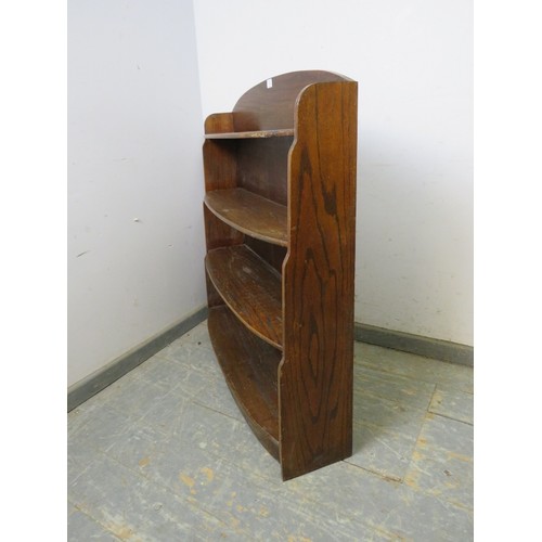 744 - An Art Deco Period oak ‘waterfall’ bow-fronted low bookcase, of four graduated shelves, on a plinth ... 