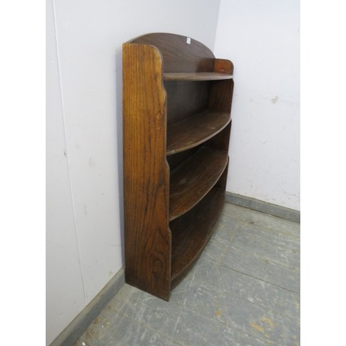 744 - An Art Deco Period oak ‘waterfall’ bow-fronted low bookcase, of four graduated shelves, on a plinth ... 