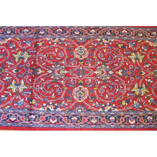 857 - North West Persian Sarouk runner, central floral field on red ground and a patterned border.  300cm ... 