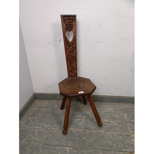 760A - A vintage medium oak Welsh spinning stool, the back with pierced heart motif and carved decoration d... 