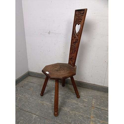 760A - A vintage medium oak Welsh spinning stool, the back with pierced heart motif and carved decoration d... 