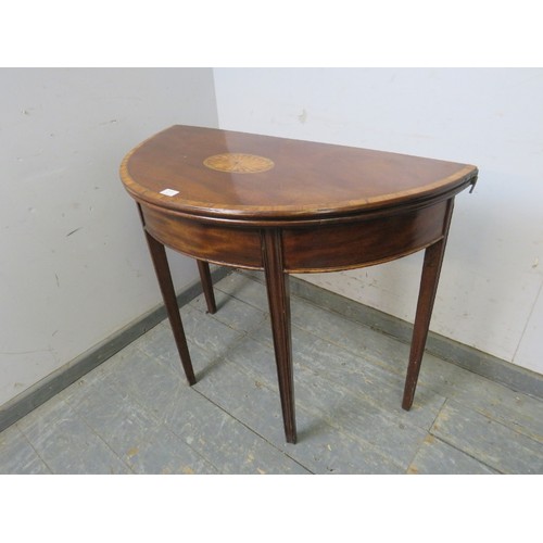 730A - A George III mahogany demi-lune folding card table, crossbanded and with inlaid satinwood panel, hou... 