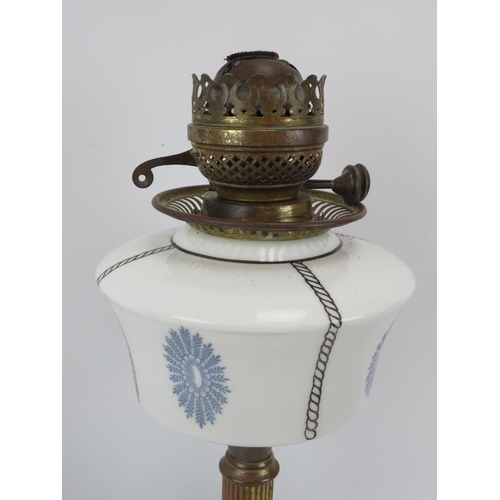 115 - A late 19th/early 20th Century oil lamp with decorated milk glass reservoir on brass column.  Height... 