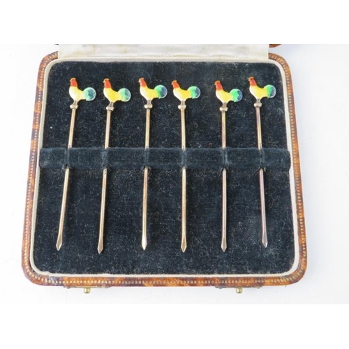 382 - A cased set of silver and cocktail sticks with enamelled cockerel terminals. Each stamped STERLING S... 