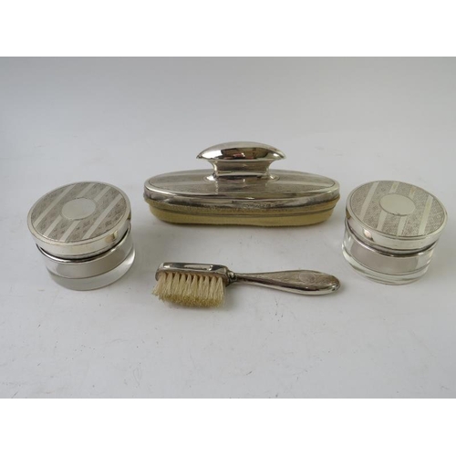 391 - A cased silver manicure part set consisting of nail buffer, brush and two silver lidded glass jars. ... 