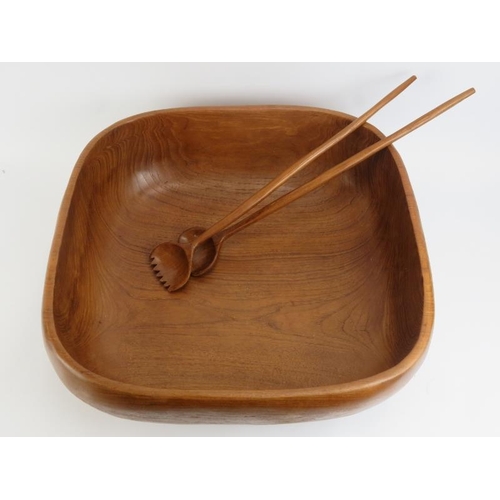 41 - A very large carved teak wood bowl with matching serving utensils. The bowl hewn from section of woo... 