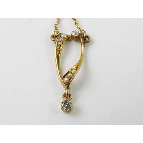 424 - A pretty pearl and diamond set wishbone pendant on yellow metal chain, bolt ring stamped 9ct, 5grams... 