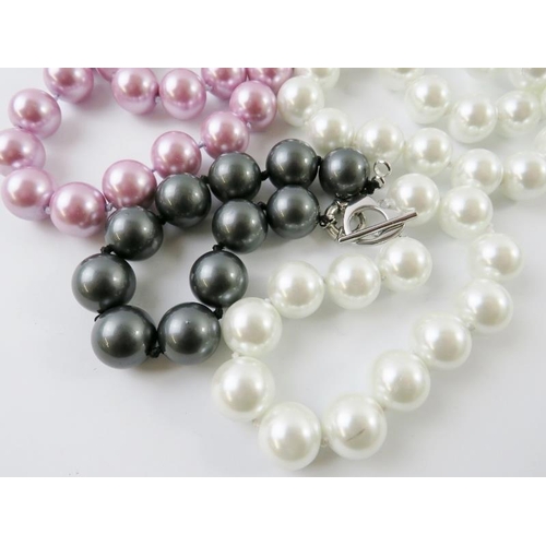 440 - An imitation South Sea pearl necklace and matching bracelet; together with a similar pink necklace a... 