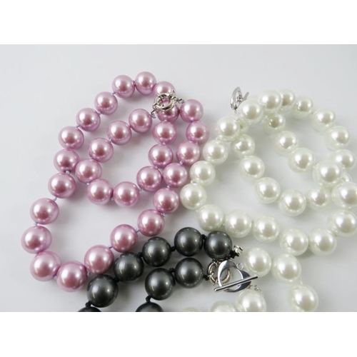 440 - An imitation South Sea pearl necklace and matching bracelet; together with a similar pink necklace a... 