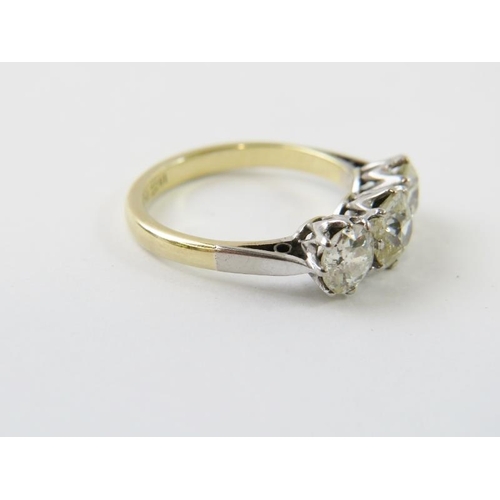 443 - A three stone diamond ring, the old cut diamonds claw set in white to a yellow metal shank.  The dia... 