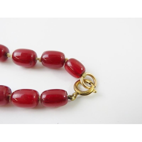 448 - A graduated strand of red ‘cherry amber’ beads, the largest 26mm x 20mm. 96.5 gms approx