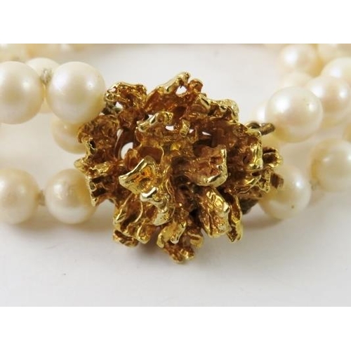 452 - A triple row cultured pearl bracelet and brutalist ‘molten gold’ yellow metal style clasp stamped 9C... 