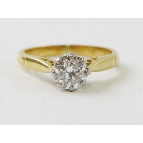 494 - A diamond single stone ring.  The round brilliant cut diamond claw set in white to a yellow metal sh... 