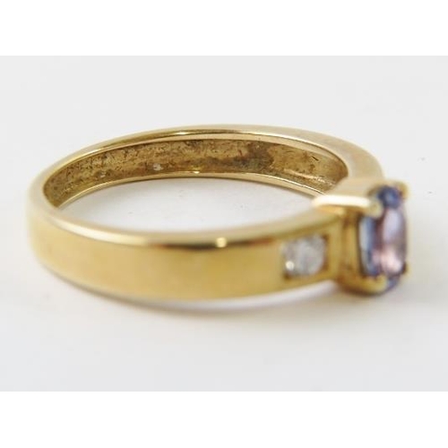 495 - A tanzanite and diamond ring in un-hallmarked yellow metal, the oval facet cut tanzanite measuring 6... 