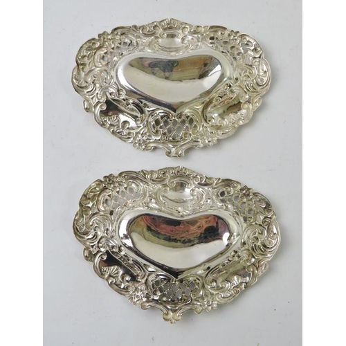 50 - A pair of heart shaped pierced and embossed pin dishes, hallmarked for Birmingham 1895. Width 10cm. ... 