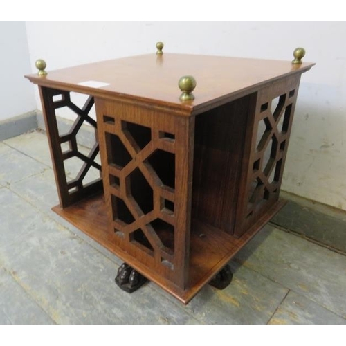 702 - An Edwardian rosewood revolving tabletop bookcase, with brass ball finials and pierced fretwork side... 