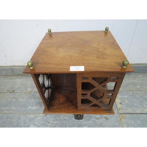 702 - An Edwardian rosewood revolving tabletop bookcase, with brass ball finials and pierced fretwork side... 