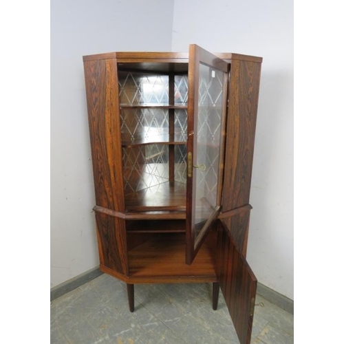 719 - A mid-century Danish corner drinks cabinet by Eli Christensen, the glazed door opening onto a mirror... 