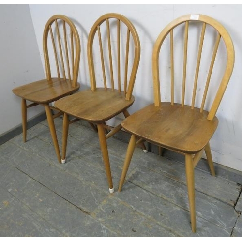 722 - Three mid-century blonde elm & beech Windsor hoop-back dining chairs by Ercol, on canted supports wi... 