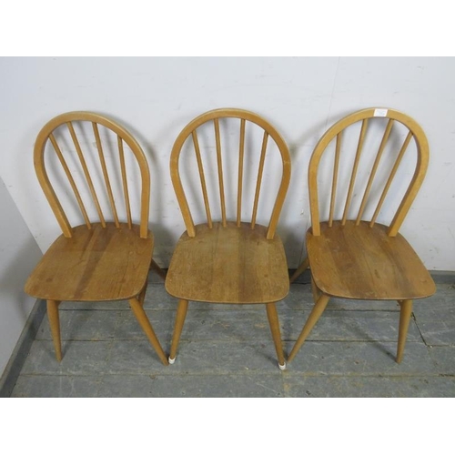 722 - Three mid-century blonde elm & beech Windsor hoop-back dining chairs by Ercol, on canted supports wi... 