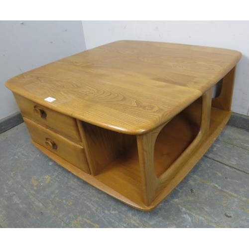 724 - A mid-century elm ‘Pandora’ Windsor coffee table by Ercol, housing two short drawers and open shelvi... 