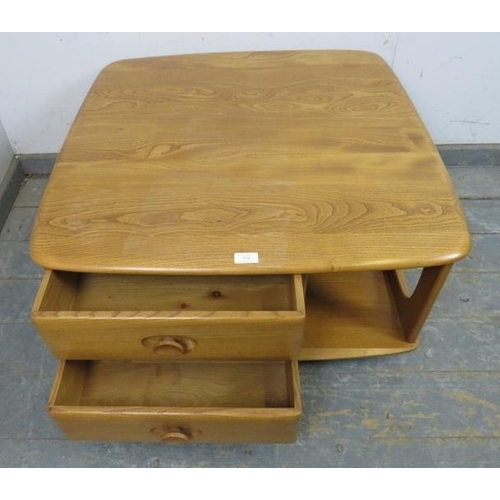 724 - A mid-century elm ‘Pandora’ Windsor coffee table by Ercol, housing two short drawers and open shelvi... 