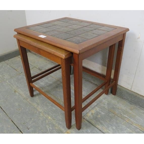 728 - Two mid-century Danish teak nesting tables, the tops with inset geometric tiles, on square supports ... 