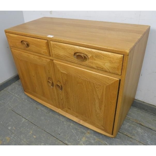 729 - A vintage elm Windsor sideboard by Ercol (model no. 3816) housing two short drawers, one with cutler... 