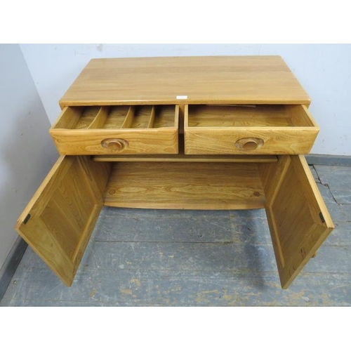 729 - A vintage elm Windsor sideboard by Ercol (model no. 3816) housing two short drawers, one with cutler... 