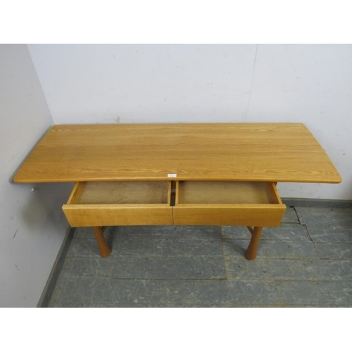 732 - A contemporary ash console table by Ercol, housing two short blind drawers, on fluted supports with ... 