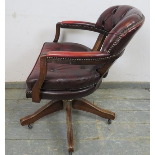 742 - A vintage mahogany captain’s desk chair, with recline and swivel function, upholstered in buttoned o... 