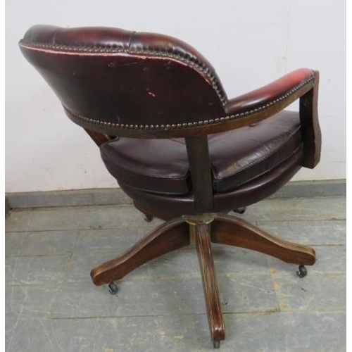 742 - A vintage mahogany captain’s desk chair, with recline and swivel function, upholstered in buttoned o... 