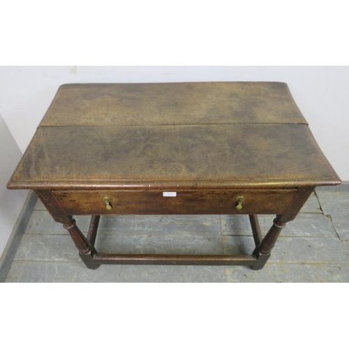 747 - An 18th century oak side table, housing one long with brass drop handles, on turned and block suppor... 