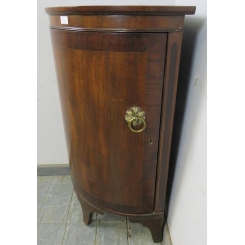 748 - A Regency Period flame mahogany bow-fronted drinks corner cabinet, the crossbanded door with ornate ... 