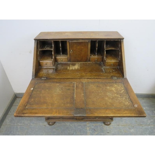 750 - A vintage oak bureau in the William & Mary taste, the fall front opening onto a fitted interior with... 