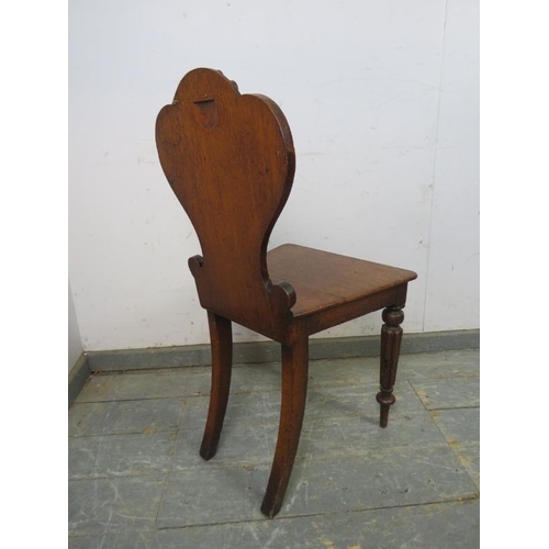 759 - A Victorian medium oak hall chair, the shaped backrest with relief carved scroll decoration, on flut... 