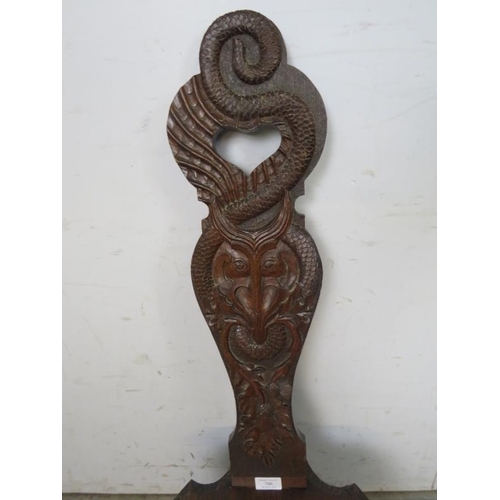 760 - A vintage oak Welsh spinning stool, the backrest ornately carved with a serpent, thistles and heart ... 