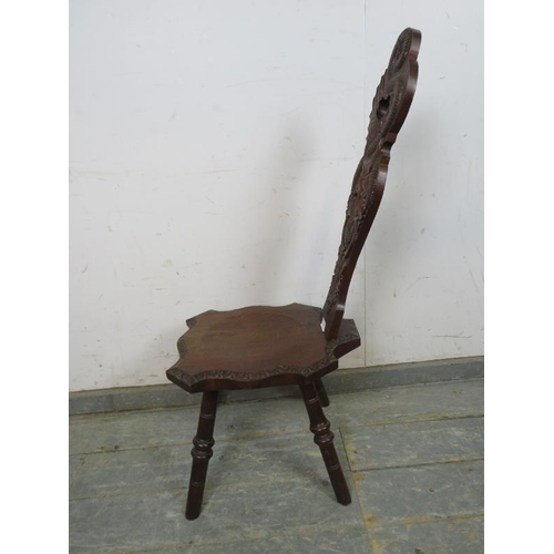 760 - A vintage oak Welsh spinning stool, the backrest ornately carved with a serpent, thistles and heart ... 