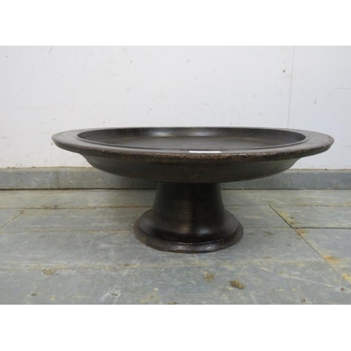 769 - A vintage turned hardwood offering tray, the dished top on a fluted pedestal base, Lombok, Indonesia... 