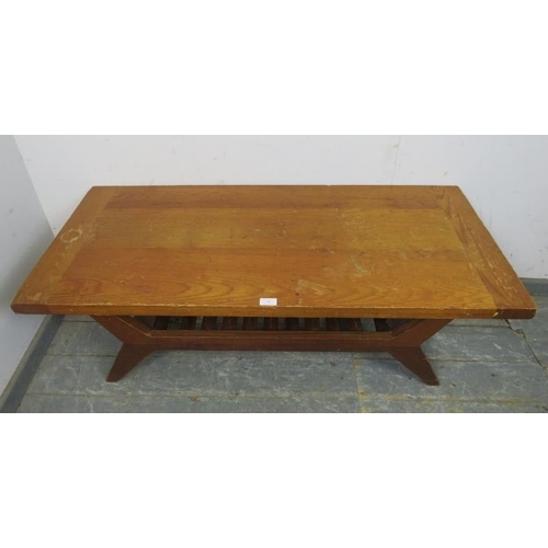 780 - A mid-century pitch pine coffee table, on canted supports with a slatted under-tier shelf.  
H45cm W... 