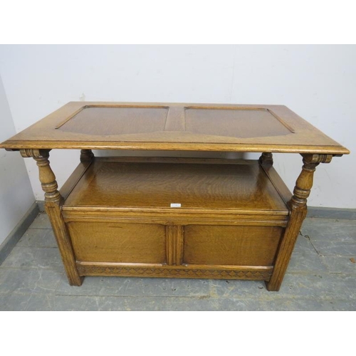 788 - A vintage medium oak monk’s bench, the folding backrest with fielded panels and carved fruit decorat... 