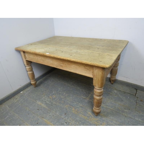 799 - An antique pine farmhouse kitchen table, having one long drawer with cast iron scalloped handles, on... 