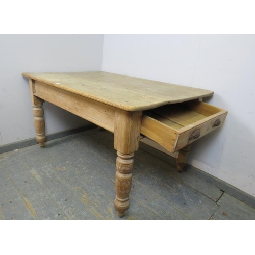 799 - An antique pine farmhouse kitchen table, having one long drawer with cast iron scalloped handles, on... 