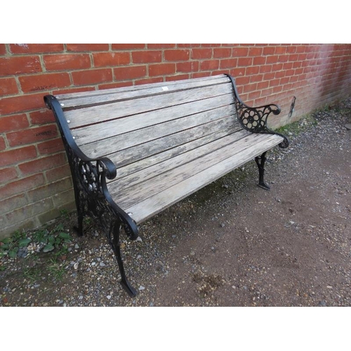 819 - A two-seater scrolled garden bench, the ornately pierced cast iron ends joined with teak slats.
H73c... 