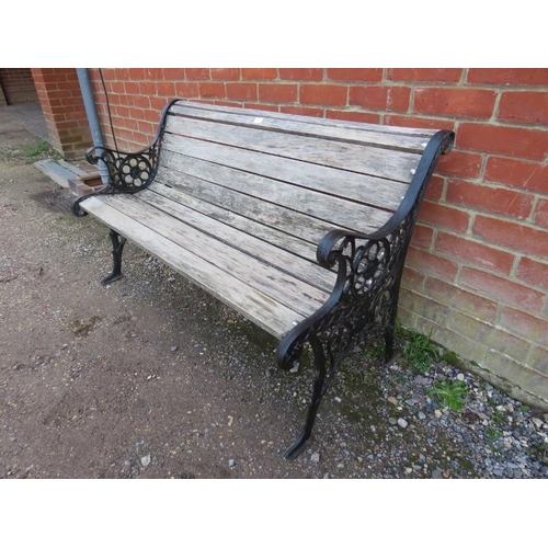 819 - A two-seater scrolled garden bench, the ornately pierced cast iron ends joined with teak slats.
H73c... 