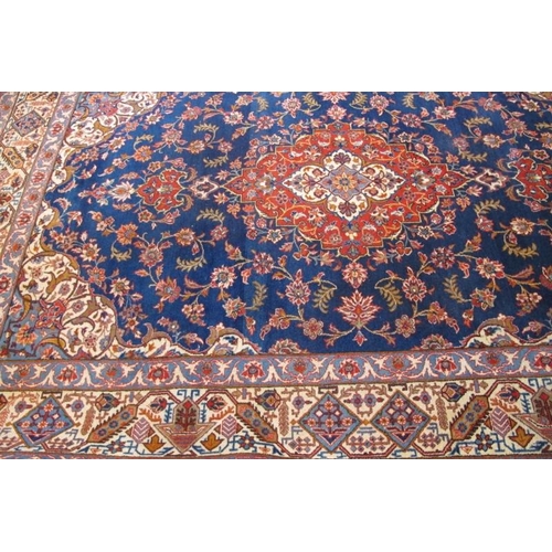 854 - A 20th Century Persian Kashan rug with central motif terracotta on blue ground. 310cm x 210cm approx... 