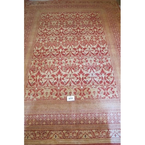 855 - A 20th Century wool carpet central patterned area and wide borders all on red ground. 328cm x 244cm ... 