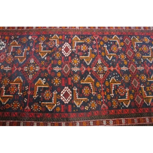 860 - A mid 20th Century Persian rug with central repeat pattern, red on black ground. 210cm x 106cm appro... 